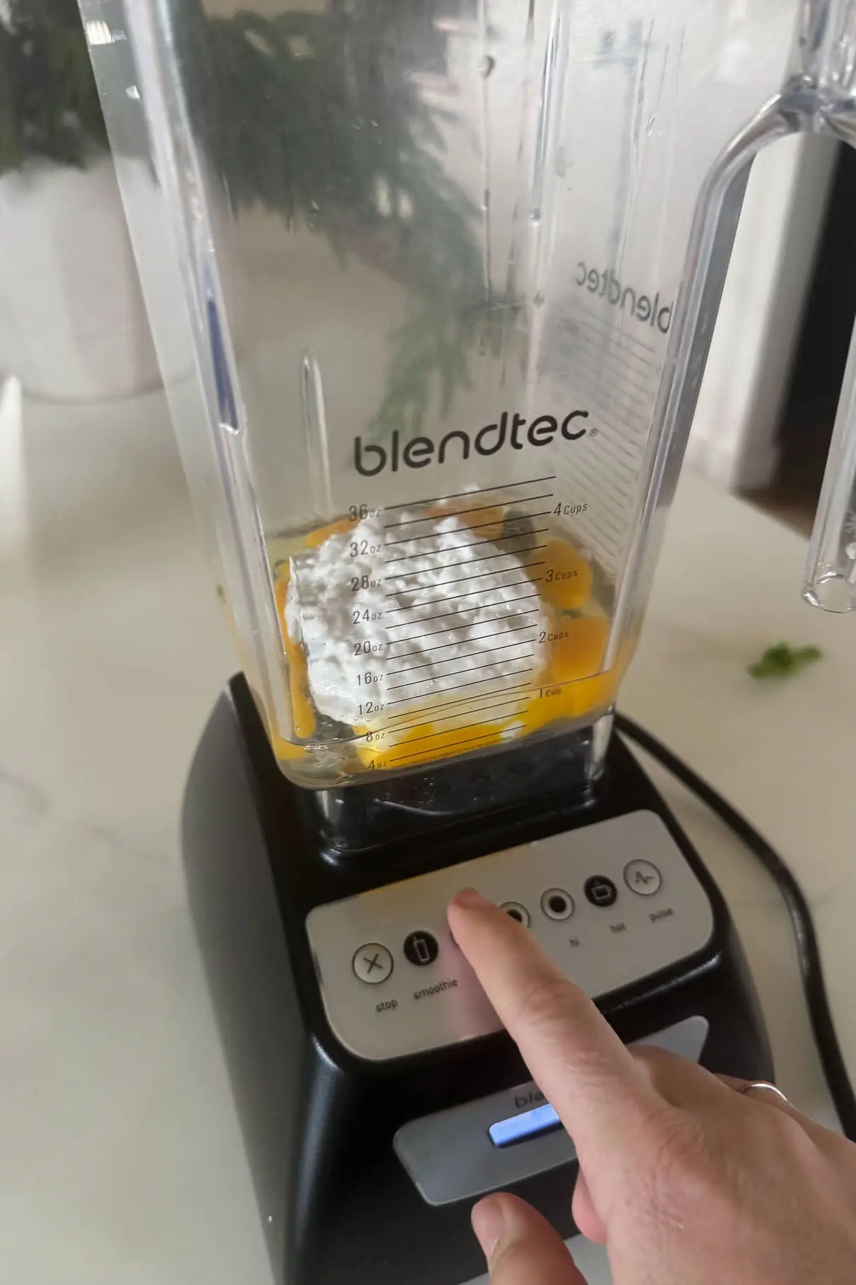 A Blendtec blender filled with cottage cheese and eggs for making a high protein pancake batter, ready to be blended.